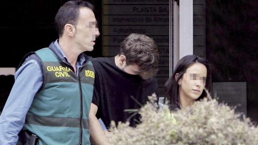 El asesino confeso, Patrick Nogueira, escoltado por dos agentes tras entregarse a las autoridades.