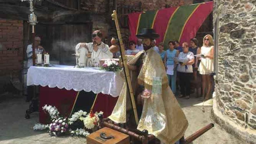 Misa en honor de san Roque celebrada en la calle. En primer plano, la imagen del santo.