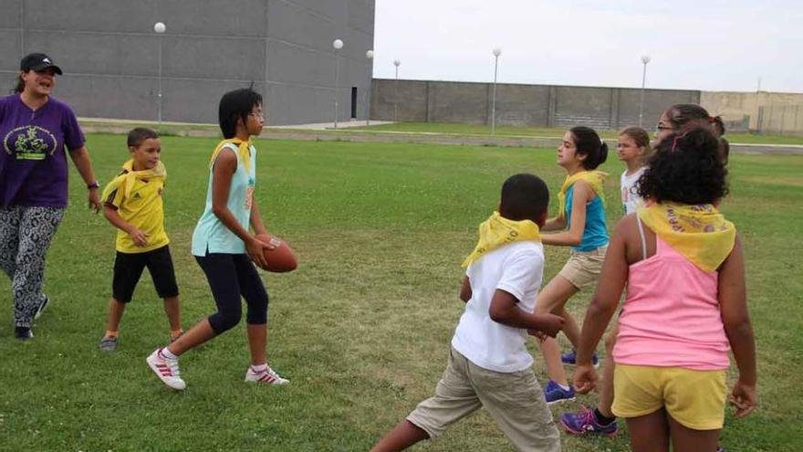 Niños y niñas juegan al rugby en el Campamento Urbano.