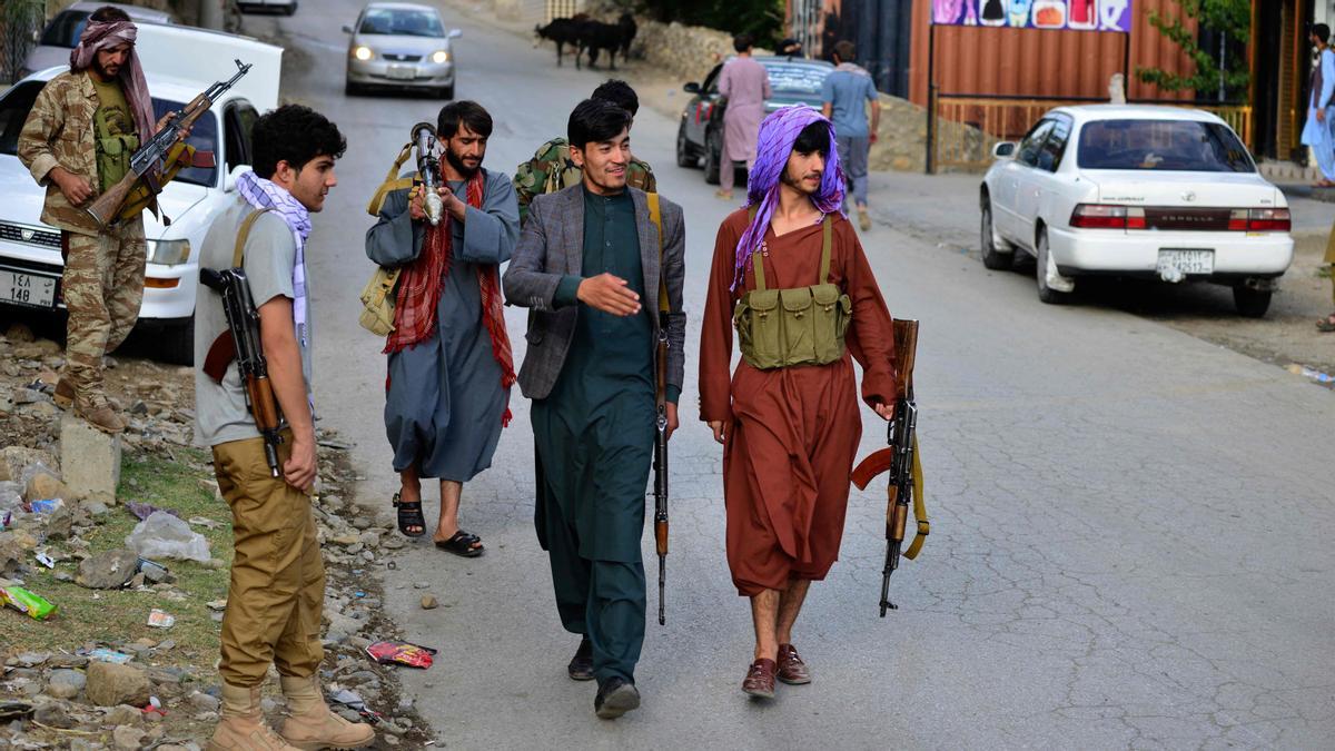Hombres armados afganos, que apoyan a las fuerzas de seguridad afganas contra los talibanes, caminan por una carretera en Bazarak, provincia de Panjshir.