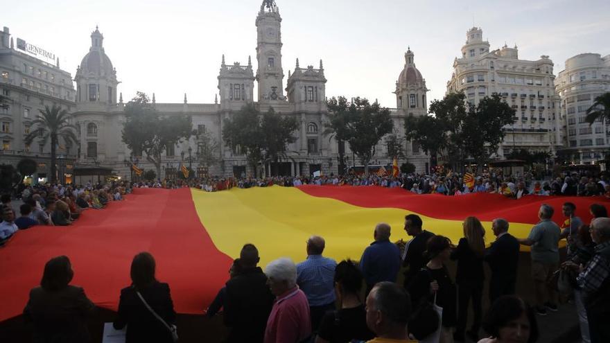 La ultraderecha exhibe una bandera de España en la plaza del Ayuntamiento de València.