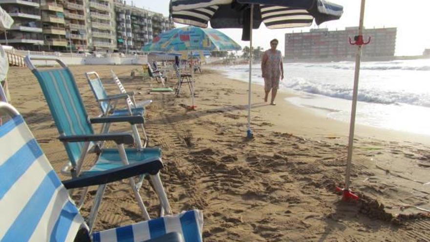 Imagen de sombrillas aparcadas en primera línea de la playa en Torrevieja.