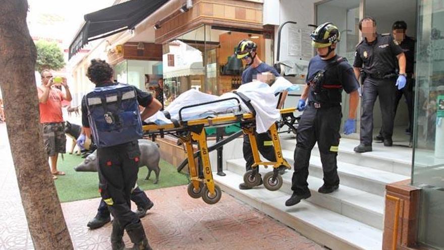 Los bomberos bajan la camilla con la mujer que se cayó en su dormitorio.