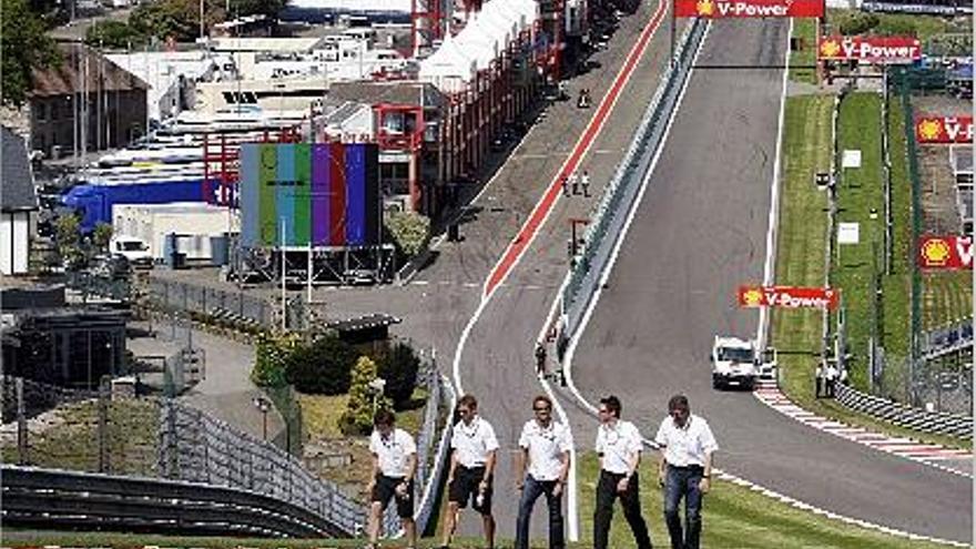 El líder Button (centro) pasea por la mítica cuesta de salida del circuito de Spa.