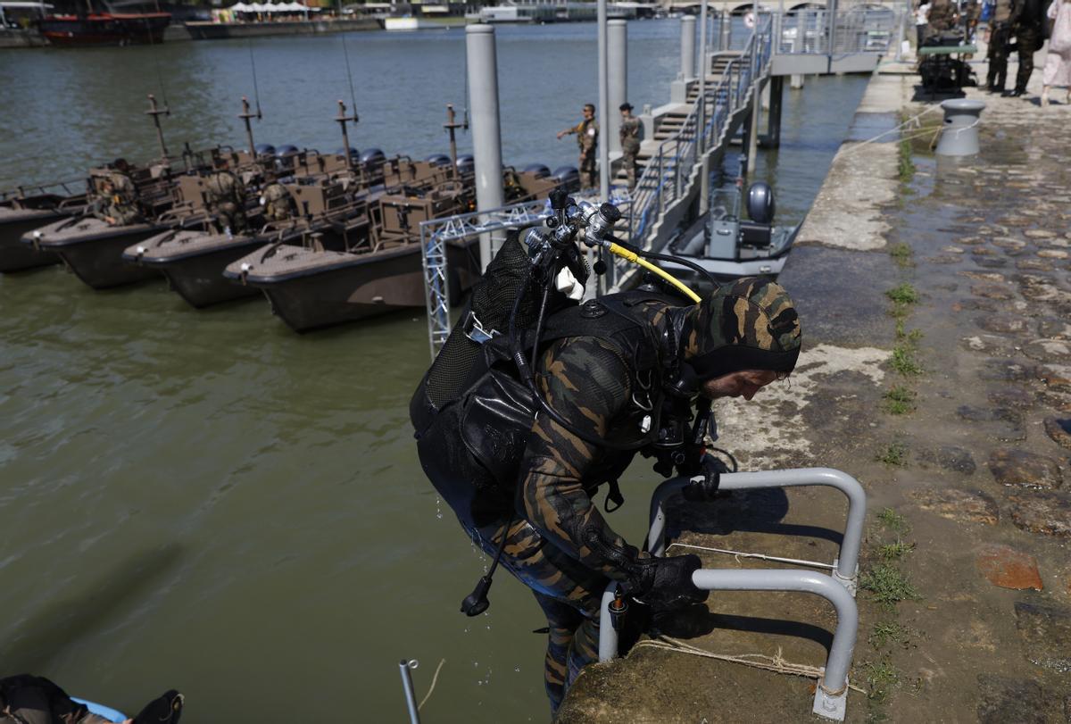 A military diver exits the Seine river after inspecting a boat ,Wednesday, July 17, 2024 in Paris. Frances armed forces held a demonstration of the security measures planned on the River Seine, both in and out of the water, to make it safe for athletes and spectators during the opening ceremony of the Paris Olympics. Organizers have planned a parade of about 10,000 athletes through the heart of the French capital on boats on the Seine along a 6-kilometer (3.7-mile) route at sunset on July 26.(AP Photo/Aurelien Morissard) / EDITORIAL USE ONLY / ONLY ITALY AND SPAIN