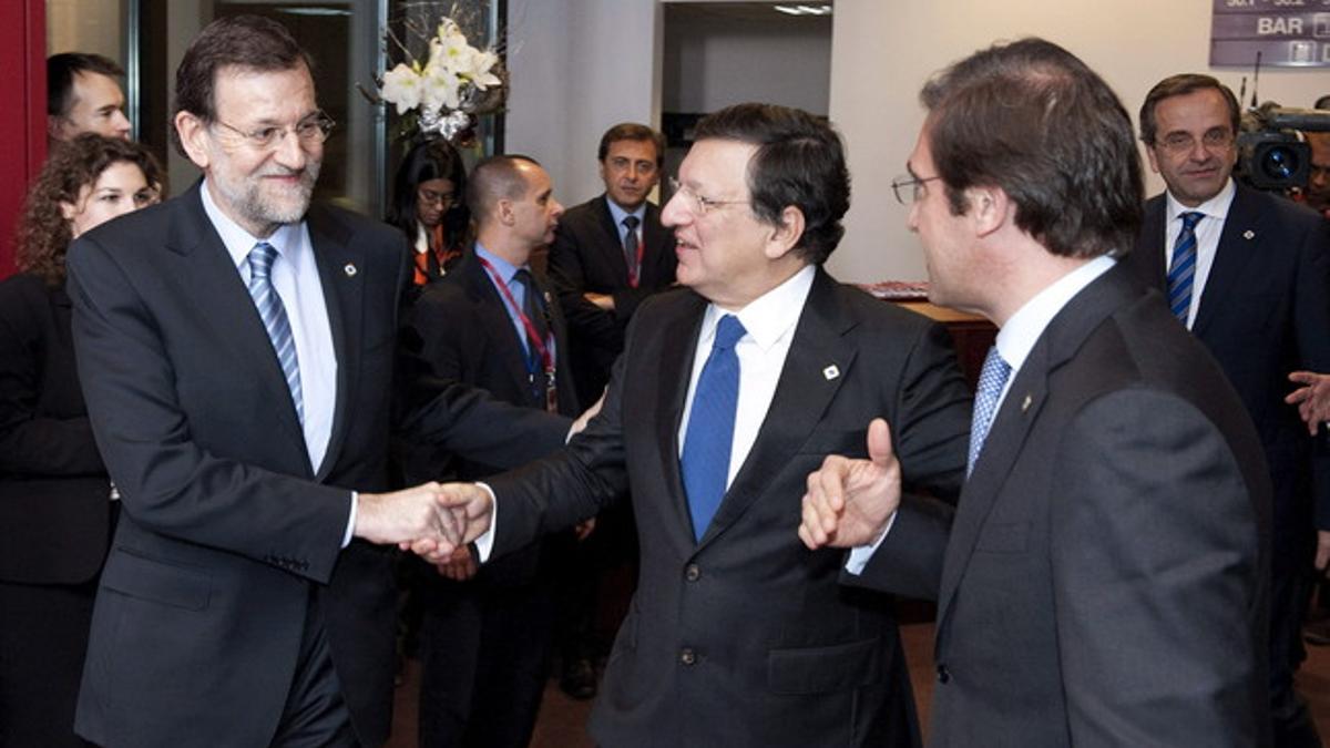 Rajoy saluda al presidente de la Comisión Europea, José Manuel Durao Barroso (centro), ante la presencia del primer ministro portugués, Pedro Passos Coelho (d), el jueves en Bruselas.