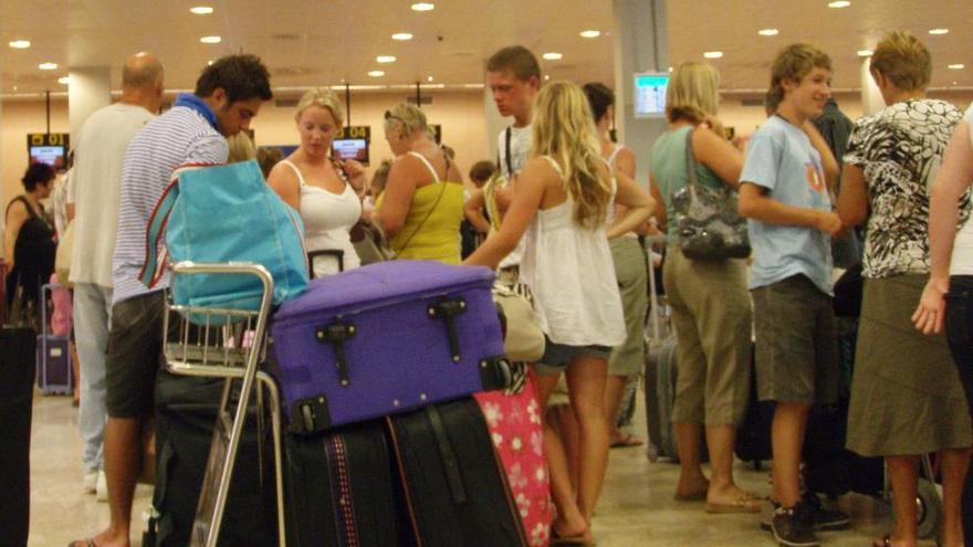 Pasajaros de San Javier hacen cola para facturar el equipaje.
