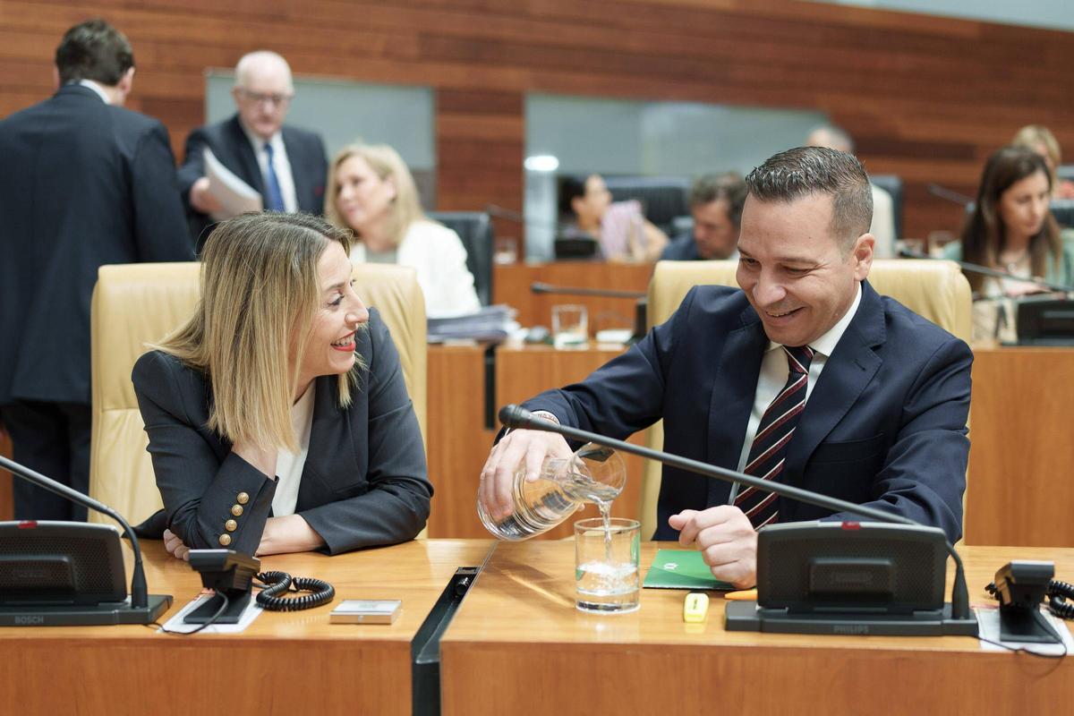 María Guardiola charla con Óscar Fernández al inicio del pleno de la Asamblea de Extremadura.