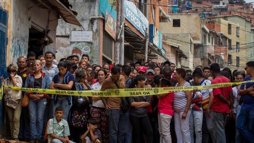 Varias personas junto a la panadería electrificada.