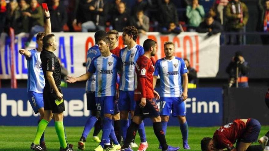 Instante en el que el árbitro le muestra la tarjeta roja al malaguista Blanco ayer en El Sadar.