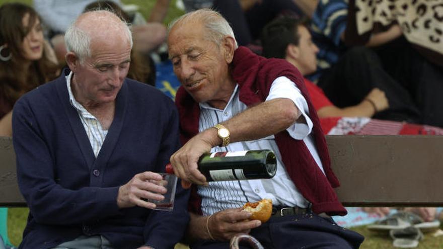 Dos amigos comparten vino y bollo en el Pura Tomás