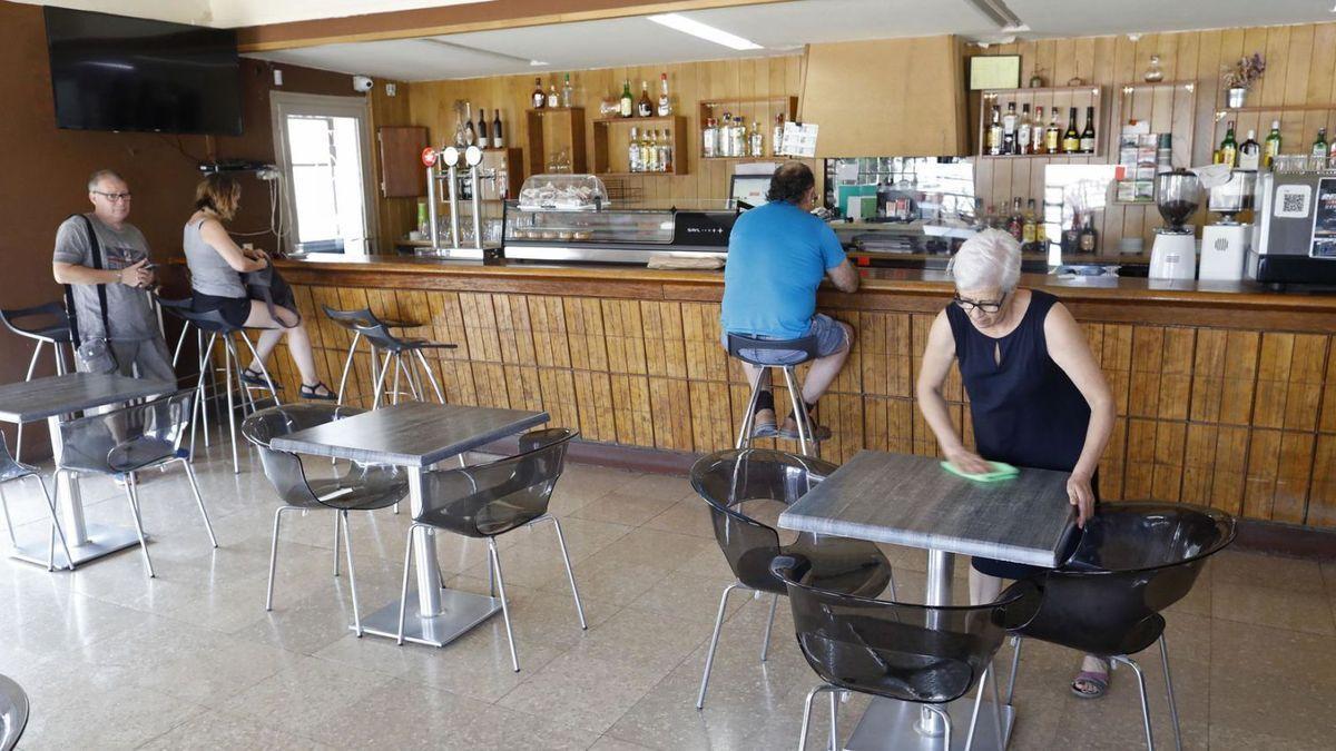 Maria Dolors Pérez neteja una taula de l’Hotel Restaurant Medinyà.