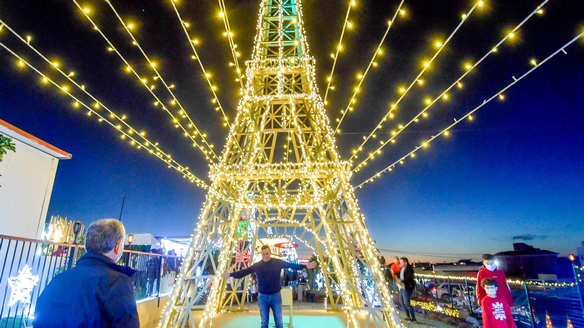 Un asistente se fotografía bajo la Torre Eiffel de 17 metros de altura.