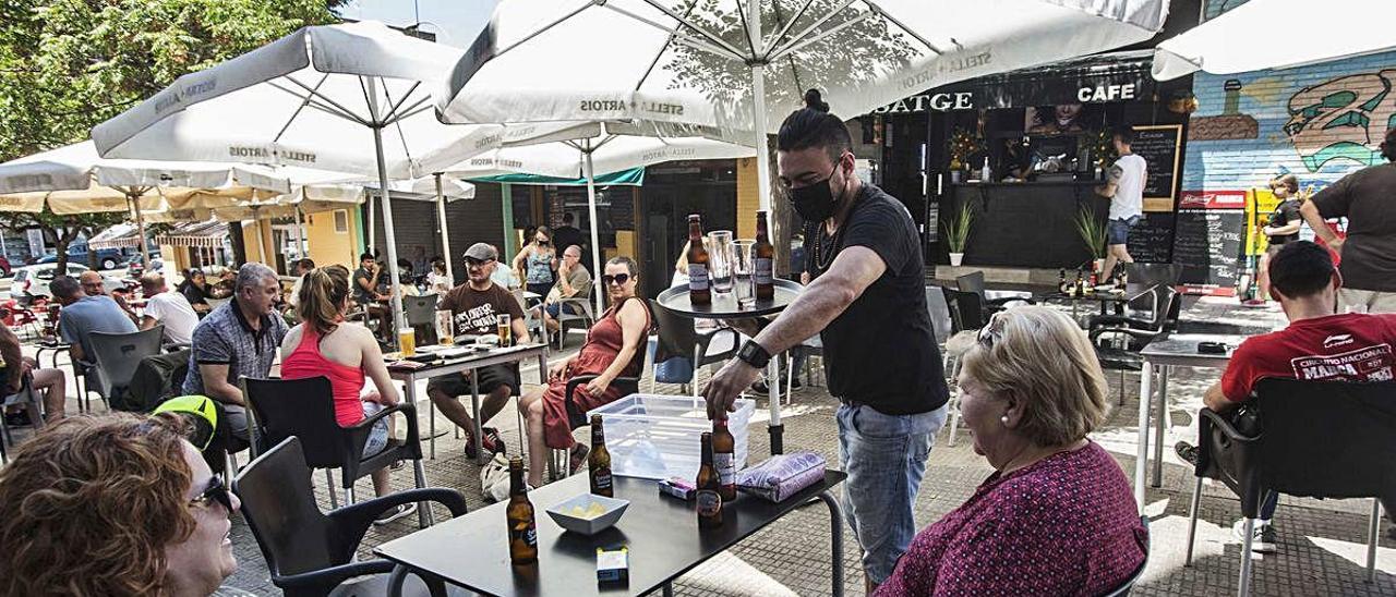 Un camarero atiende a los clientes en una terraza de Alicante.