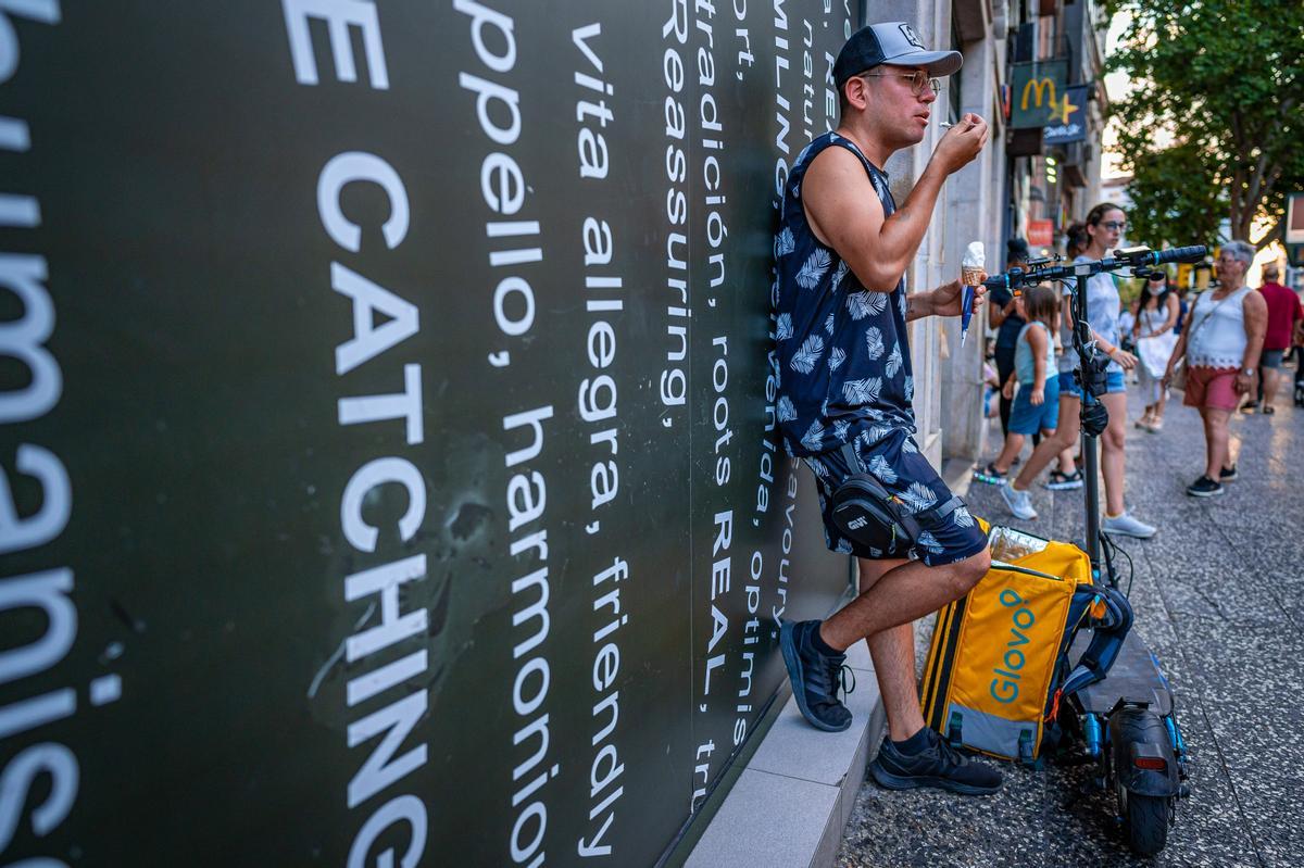 Un repartidor se come un helado en la puerta del McDonald's del Coso, justo antes de empezar una noche de repartos.