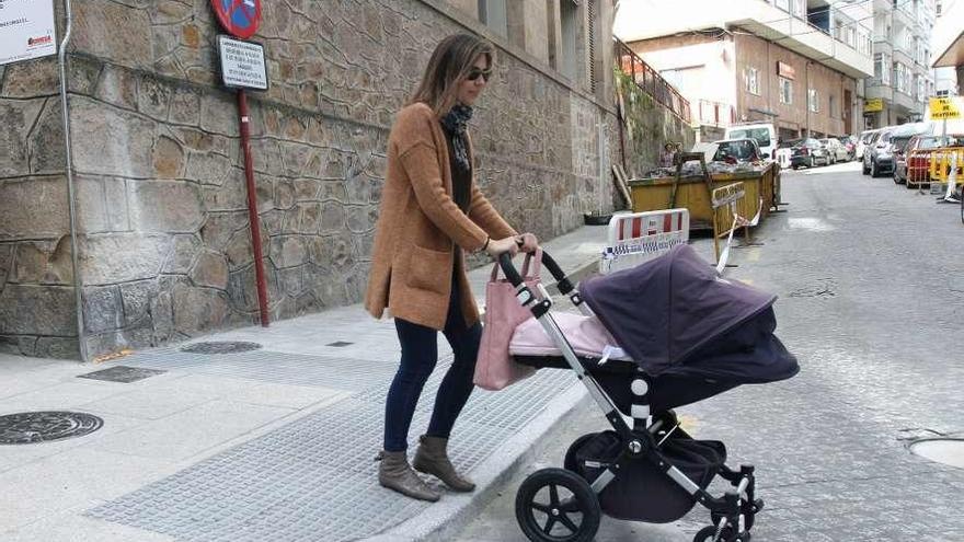 Una mujer pasea por la calle con su bebé.