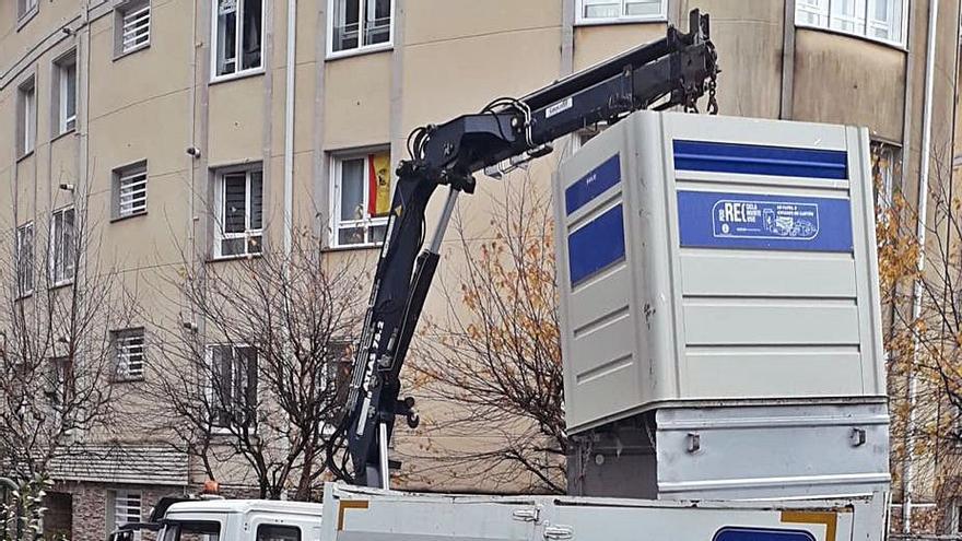 Un camión retira cartón para su reciclaje de un contenedor en Poio.