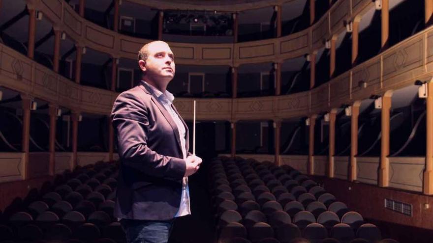 David Rivas Domínguez, con una batuta en la mano, posa en el escenario del teatro.