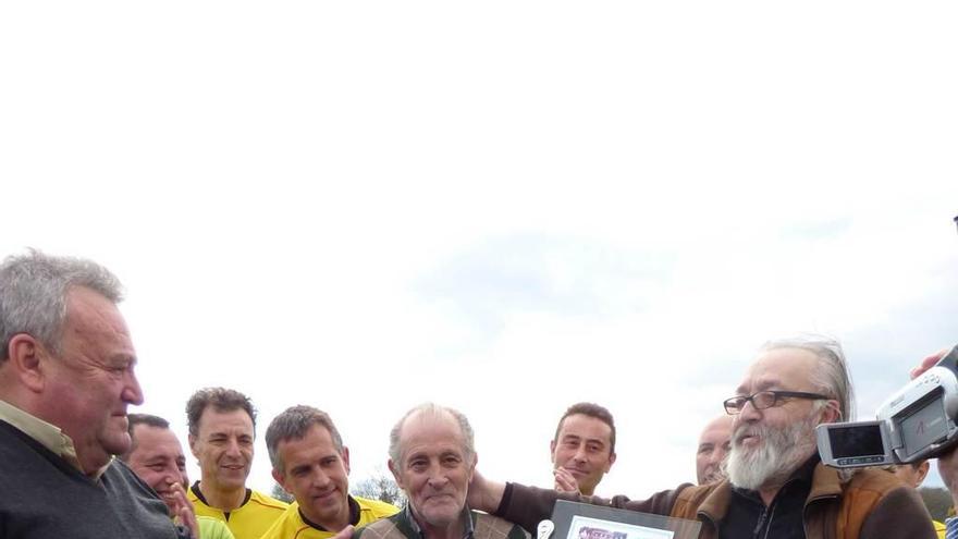 Miguel Ángel Mijares, junto a su nieta Elsa, recoge la placa que le entregó Fernando Suárez rodeado de amigos y jugadores.