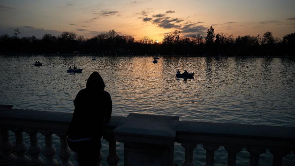Una persona observa el atardecer en el Parque del Retiro