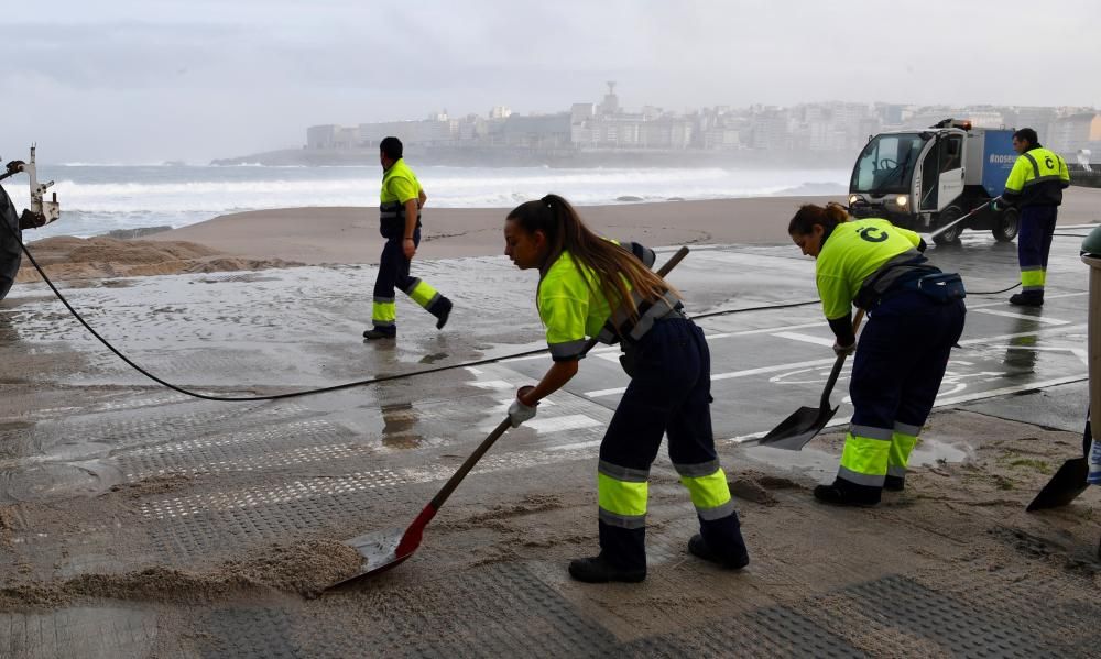 El mar empuja arena al paseo, cortado al tráfico