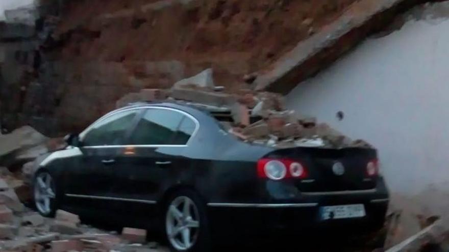 La caída de un muro destroza un coche que estaba estacionado