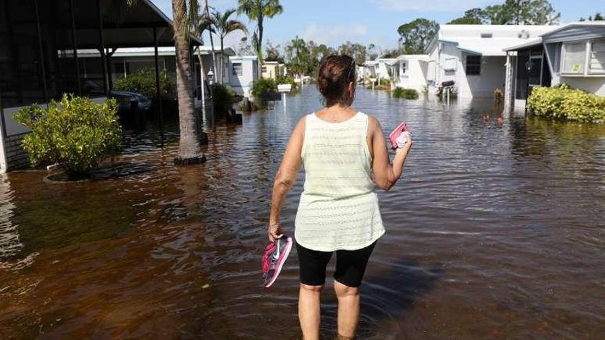 Una mujer camina por una calle anegada de Naples, en Florida.