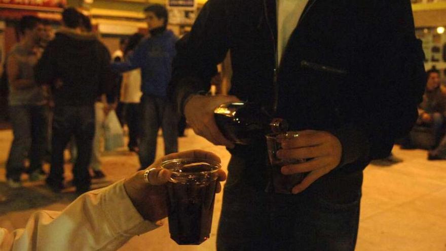 Jóvenes se sirven alcohol en un &#039;botellón&#039;.