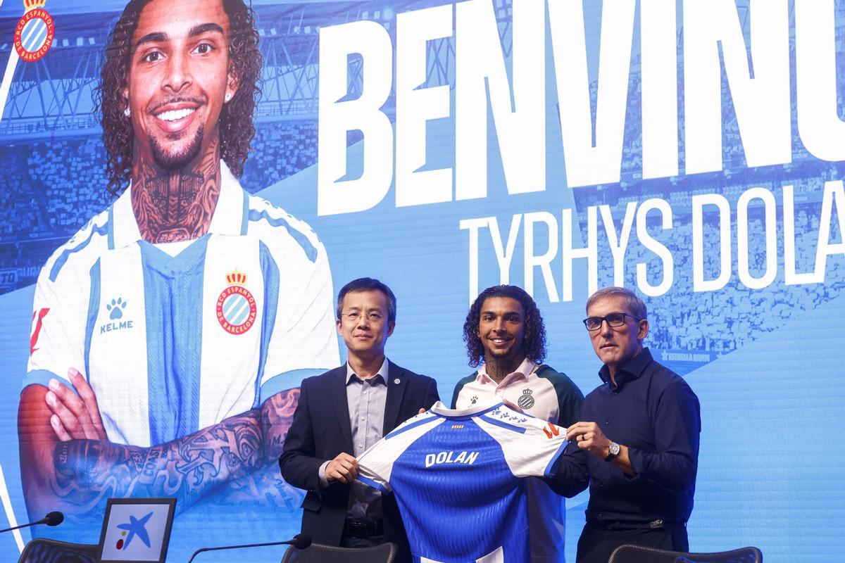 GRAFCAT1120 Cornellà de Llobregat (BARCELONA) 05/08/2025.- El delantero británico Tyrhys Dolan, acompañado por el CEO del club blanquiazul, Mao Ye (i) y del director deportivo, Fran Garagarza (d), atiende a los medios de comunicación durante la presentación este mediodía como nuevo jugador del RCD Espanyol de Barcelona. EFE/ Quique García