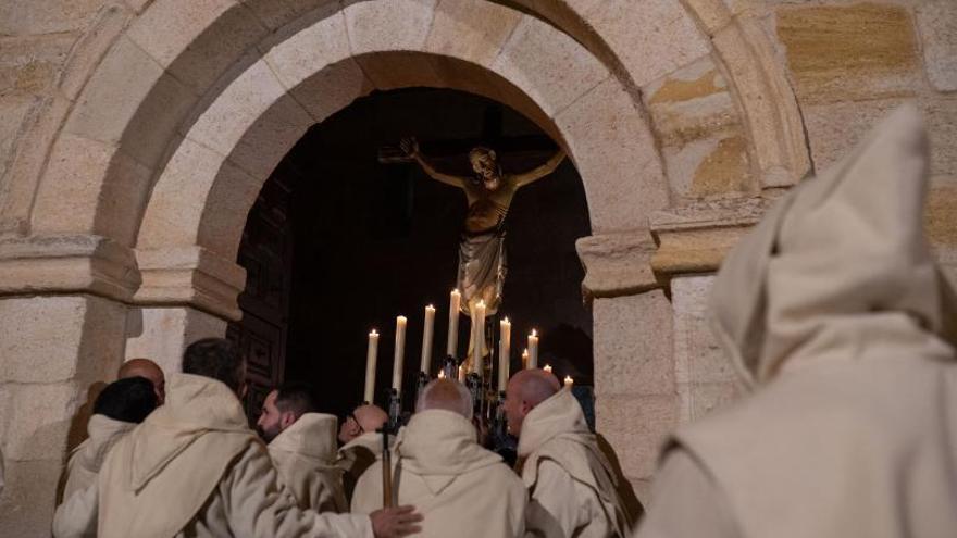 Los hermanos de paso maniobran para salvar la puerta del templo del Espíritu Santo con la imagen titular.