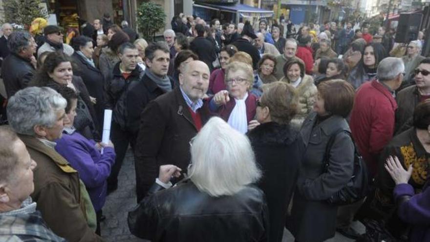 El alcalde y Luisa Varela, presidenta de la federación vecinal, descubren un banco en la avenida. / víctor echave