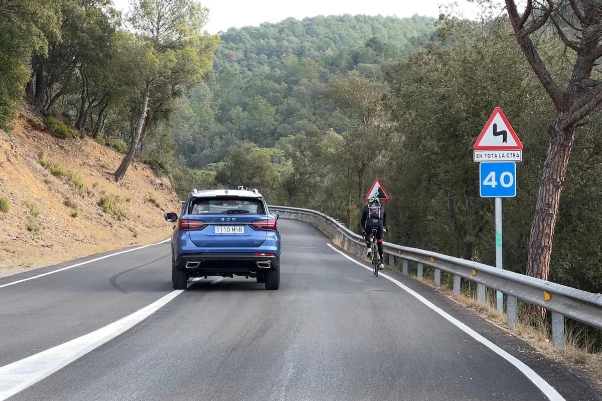 Un cotxe, avançant un ciclista a la carretera dels Àngels a Girona