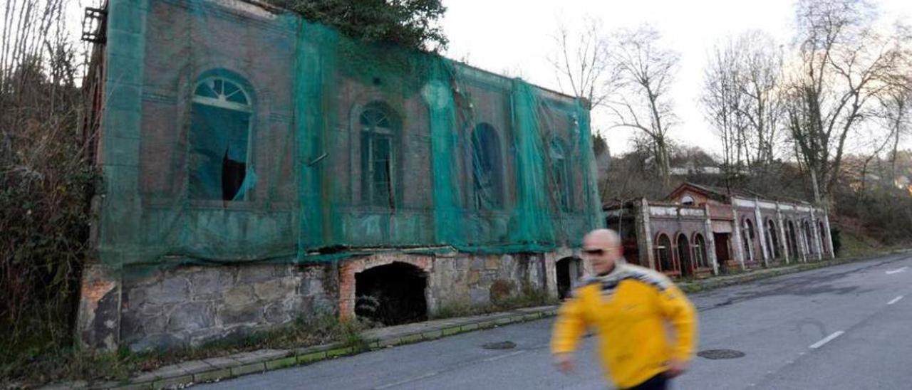 Un vecino pasa por delante de los edificios que van a ser rehabilitados.