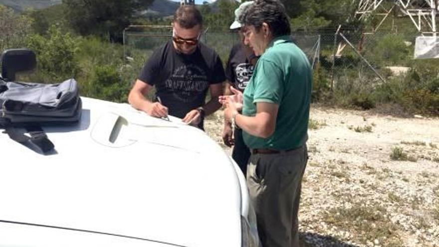 El concejal Torres y dos técnicos revisan documentos junto a la parcela.