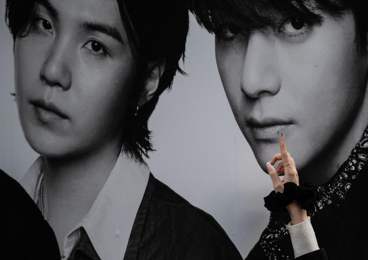 Una fan del grupo coreano BTS toca los labios de un miembro del grupo en un póster en el Tokyo Dome antes del inicio de la primera gira mundial de BTS, «Arirang», en Tokio el 17 de abril de 2026. Decenas de miles de fans esperaban con entusiasmo a las afueras del emblemático estadio de Tokio para ver a BTS en su primer concierto fuera de Corea del Sur tras el inicio de su gira mundial. (Foto de Andrew CABALLERO-REYNOLDS / AFP)