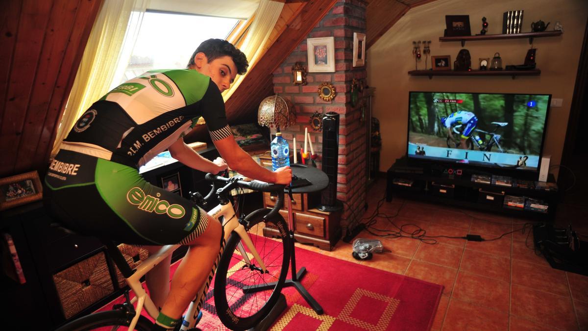 El vilagarciano entrenando en su casa y con el ciclismo en la pantalla de televisión.