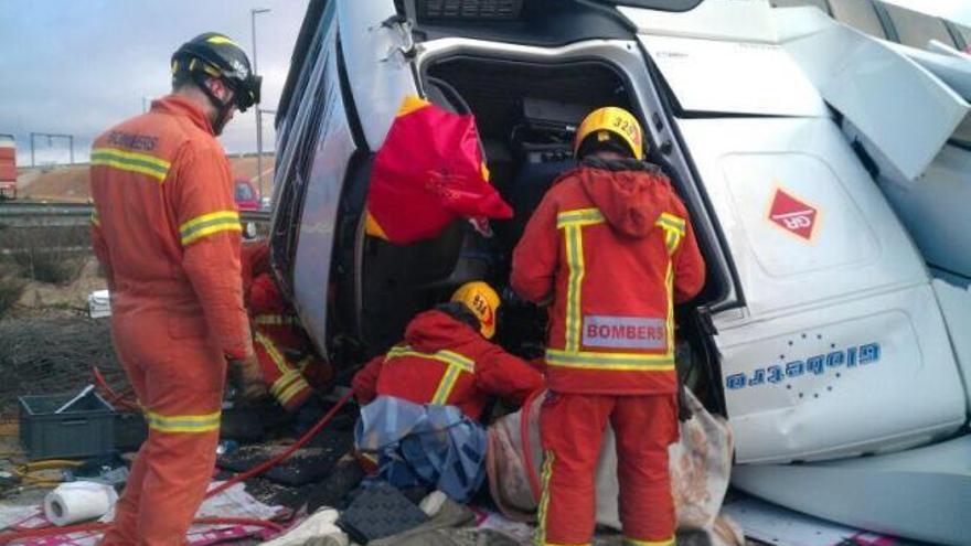 Los bomberos tratan de rescatar al camionero en Requena.