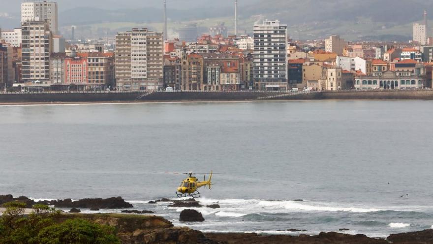 Helicóptero de Bomberos de Asturias rastreando la costa de Gijón.