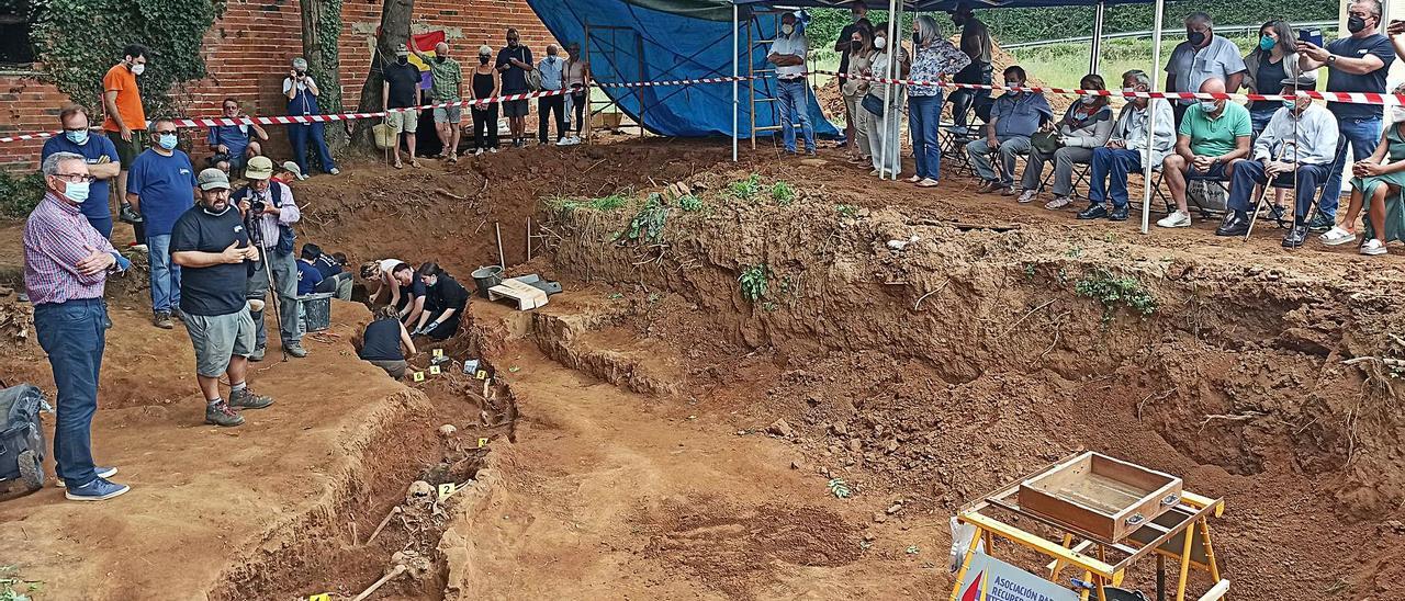 José Sierra, exalcalde de Grado (primero por la izquierda) y Marco Antonio González, vicepresidente de la Asociación para la Recuperación de la Memoria Histórica (ARMH), explican a los familiares de las víctimas los trabajos de exhumación de la fosa de El Rellán, ayer, en Grado. | S. Arias