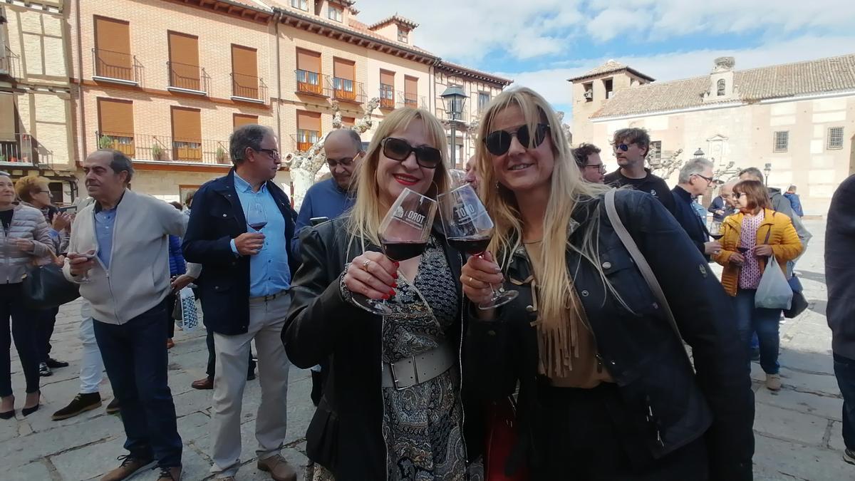 Dos participantes en la celebración brindan con sus copas por el vino de Toro