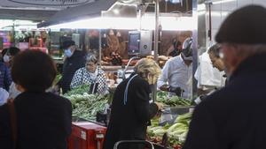 Varios personas en un mercado en el día el primer día sin mascarillas en interiores.