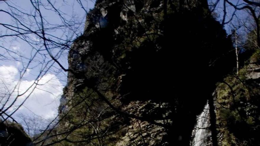 Un turista observa una cascada en la Ruta del Alba, en Redes.