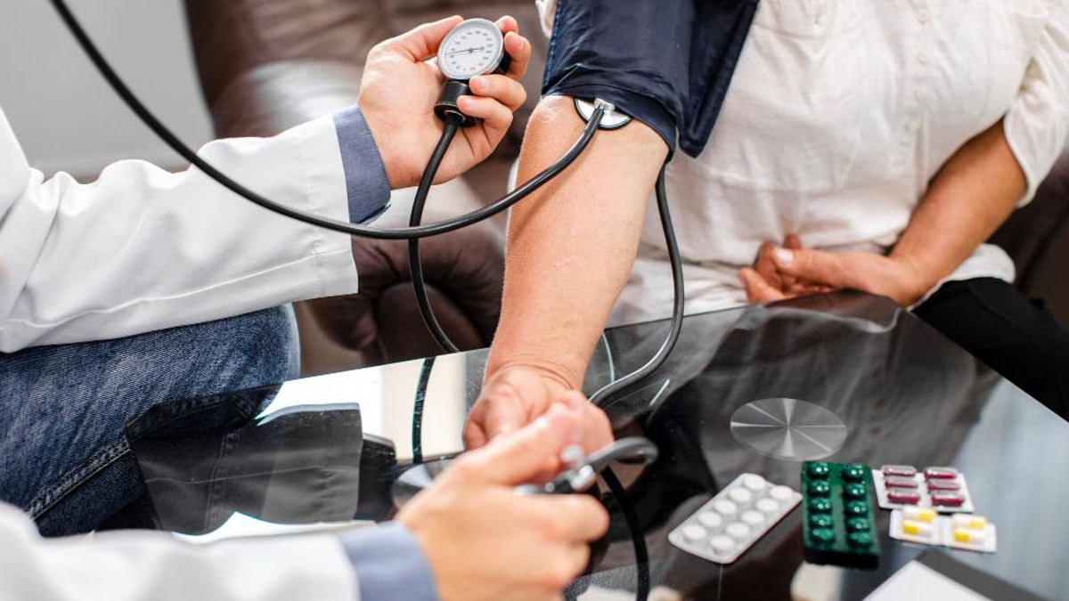 doctor masculino manos medir la tension un paciente
