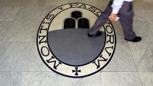 Un hombre camina sobre el logo del banco Monte Dei Paschi Di Siena en Roma. 