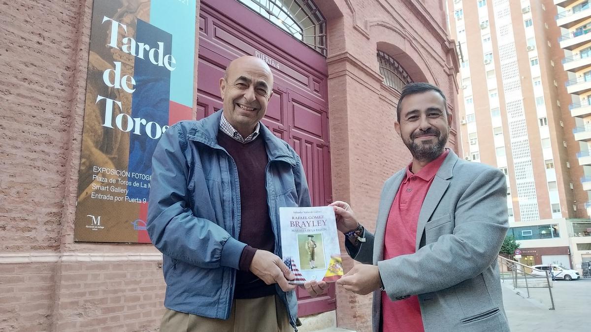 El familiar del torero, José Luis Rodríguez Palomo, con Salvador Valverde y su libro, en La Malagueta.