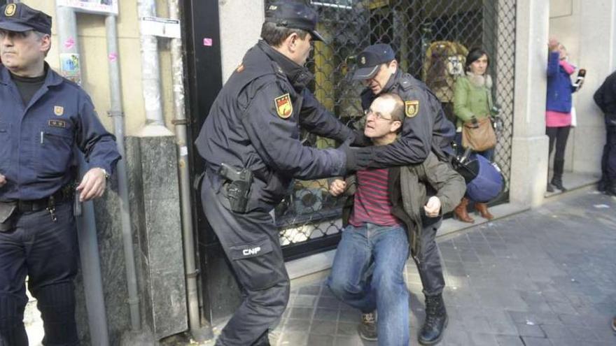 Dos policías nacionales sujetan a Xosé Manuel Carril, en 2014, durante el desahucio de Aurelia Rey.