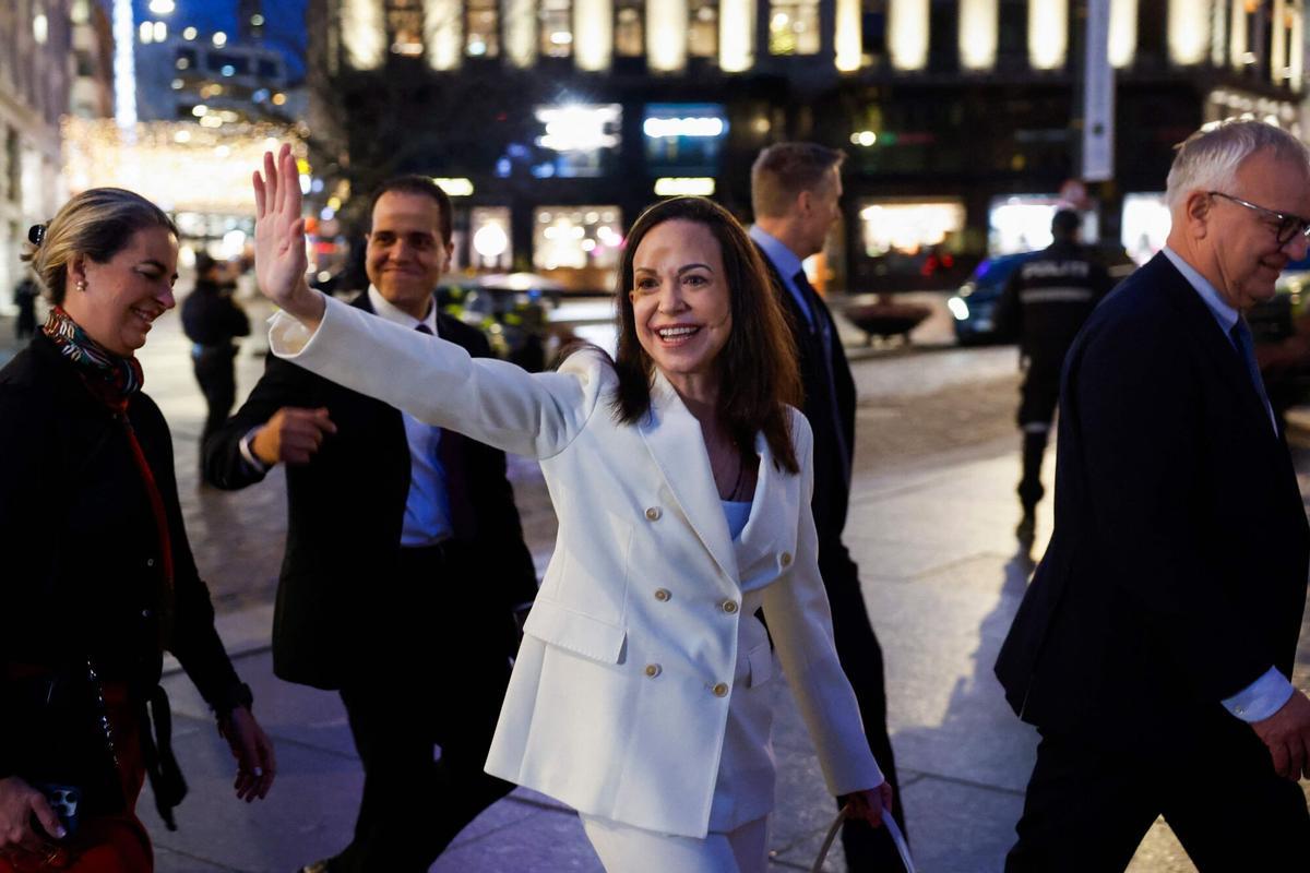 Nobel peace laureate Maria Corina Machado waves to supporters as she walks towards the Parliament for a visit in Oslo, on December 11, 2025. Machado arrived in Oslo hours after the Venezuelan opposition leaders award was collected on her behalf by her daughter. (Photo by Odd ANDERSEN / AFP)