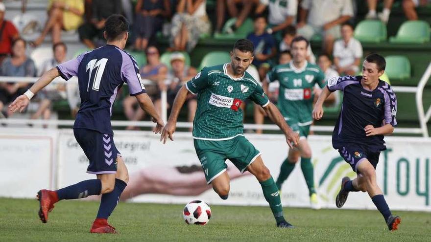 Silva, del Coruxo, controla el balón ante la presión de Waldo, ayer, en el campo de O Vao. // R. Grobas