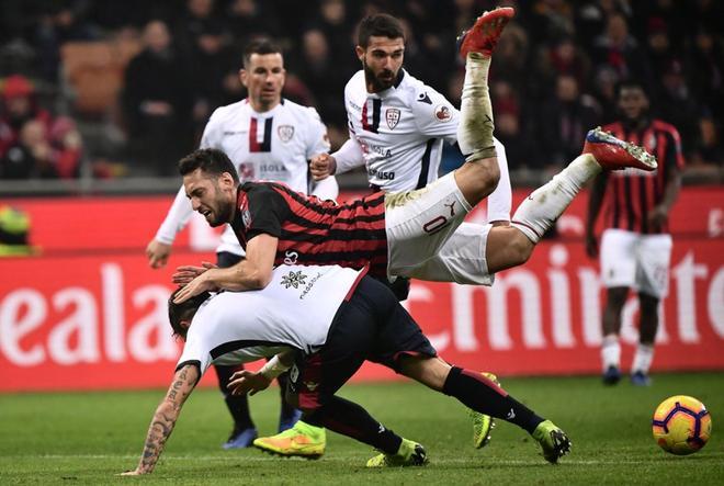 El turco Hakan Calhanoglu (arriba) del AC Milan choca con el defensor italiano de Cagliari, Luca Ceppitelli, durante el partido de la Serie A, disputado en el Estadio San Siro de Milán.