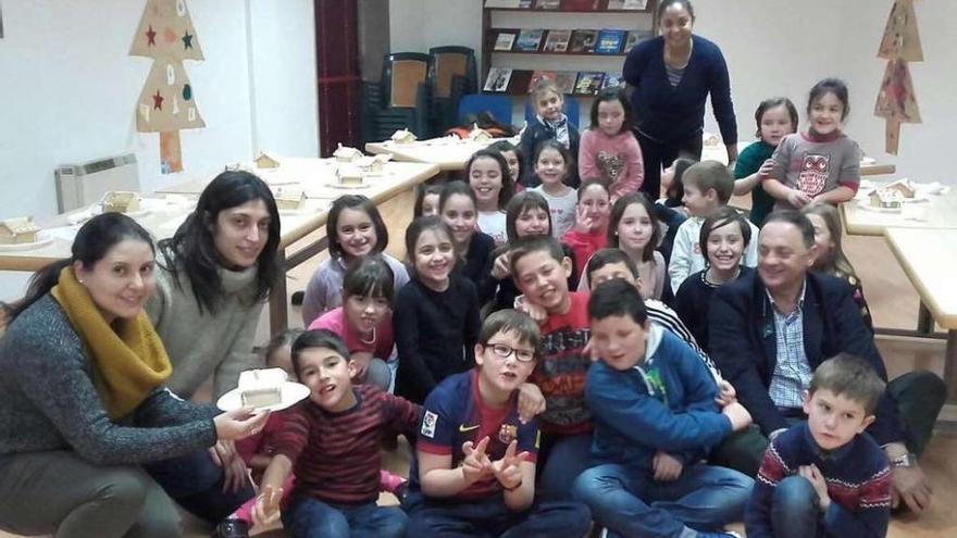 La edil Beatriz Iglesias (izquierda) y el alcalde, Jesús Otero (derecha), junto a los niños de la ludoteca.